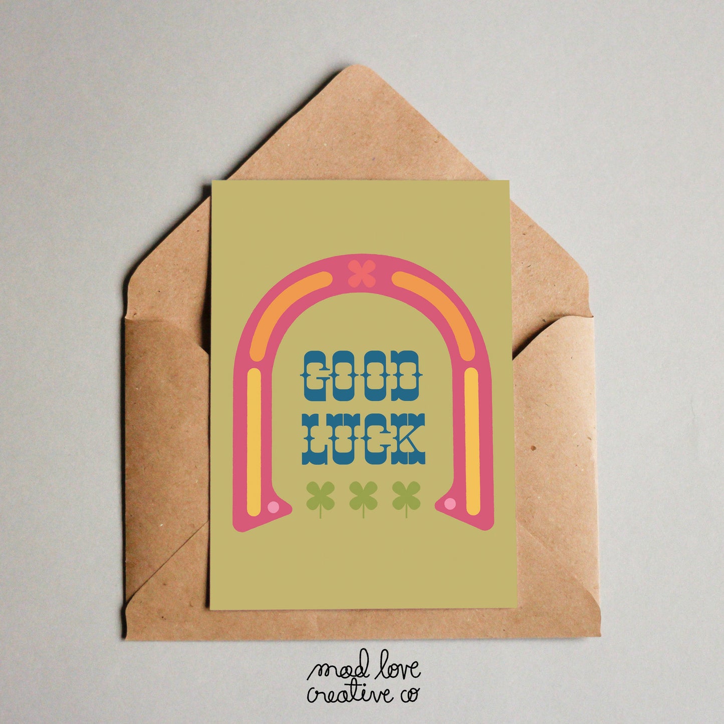 Cute good luck card with a horseshoe and four leafed clovers on a green background. Made in Canada by Mad Love Creative Co.