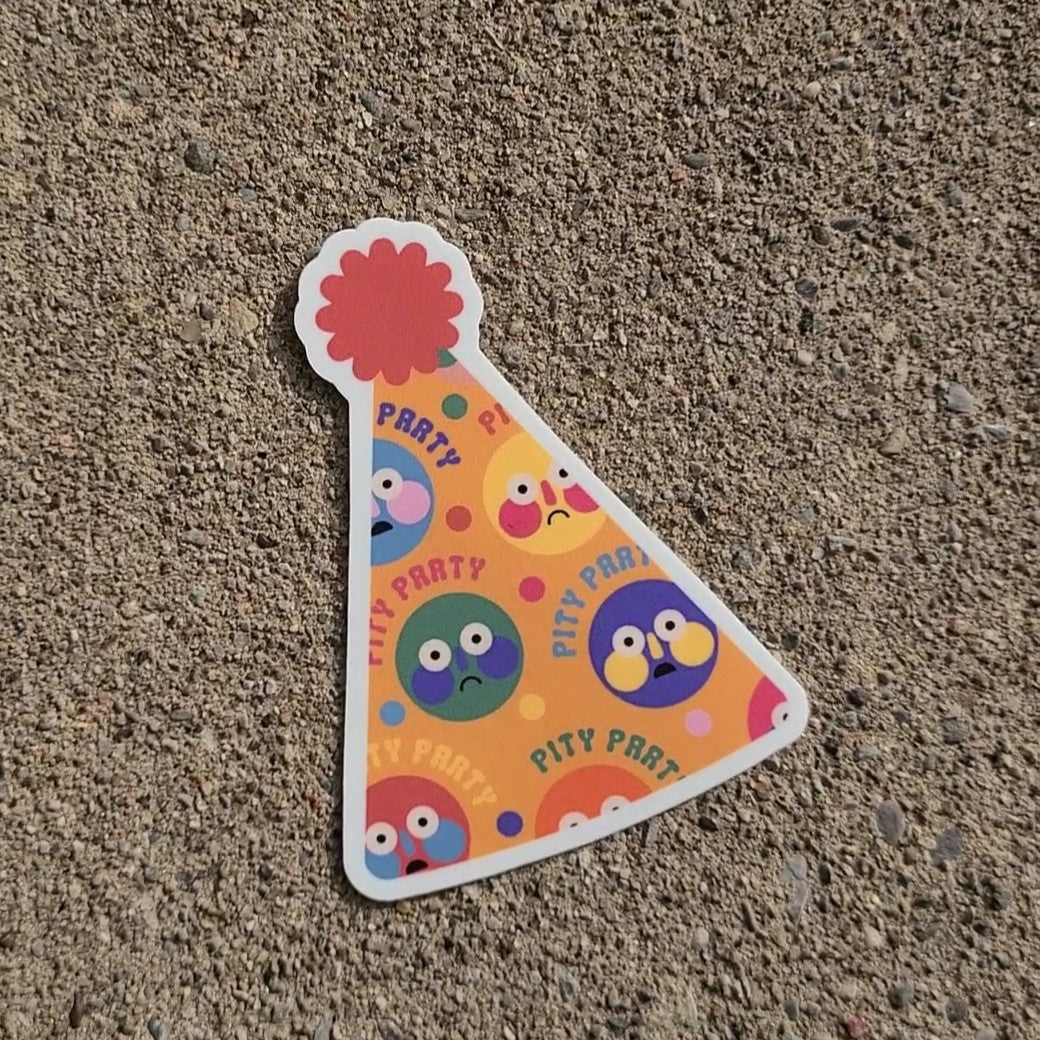 Party hat sticker with sad and surprised face pattern that says "Pity Party". Made in Canada by Mad Love Creative Co.