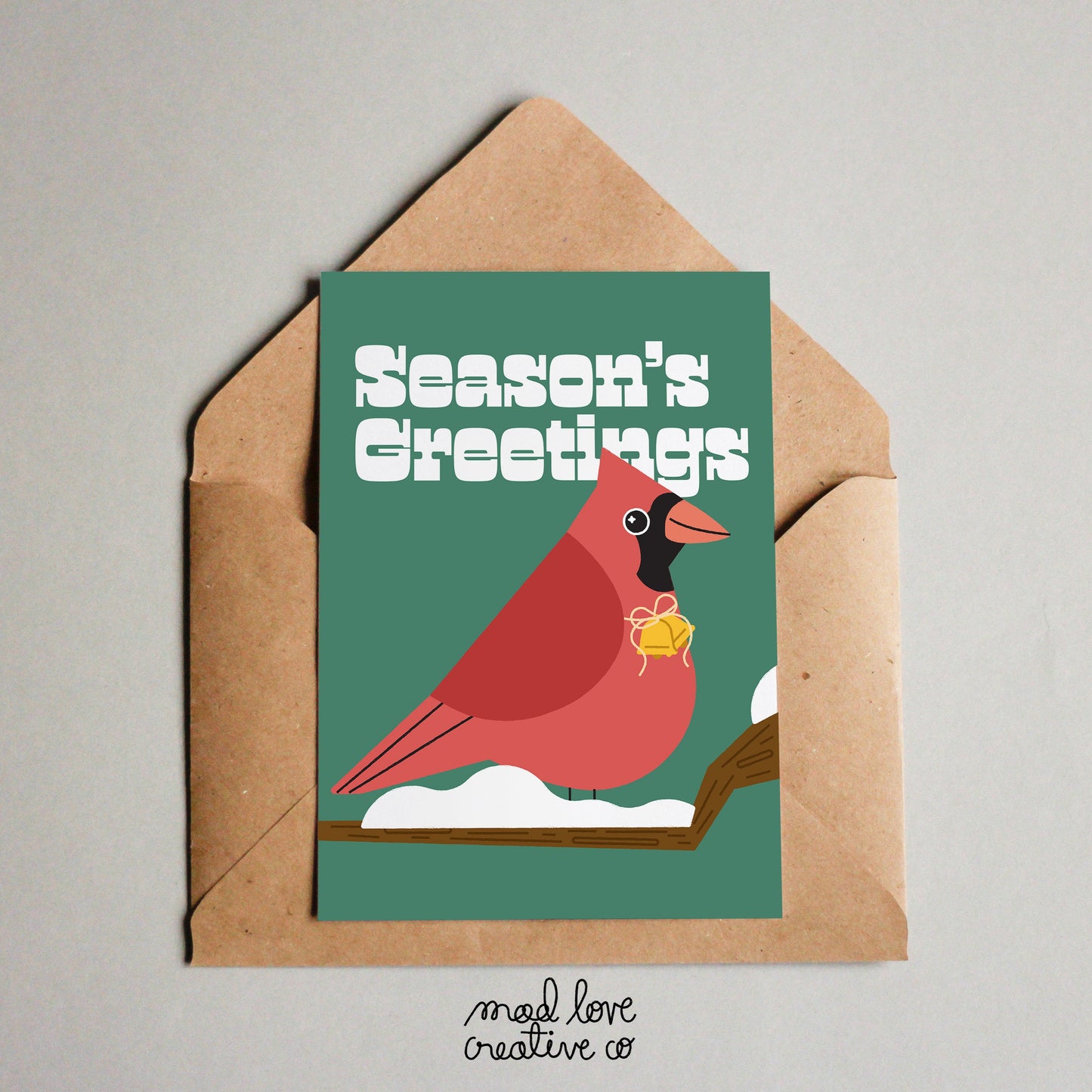 Cute holiday card that says "season's greetings" featuring a cardinal on a snowy branch. Made in Canada by Mad Love Creative Co.