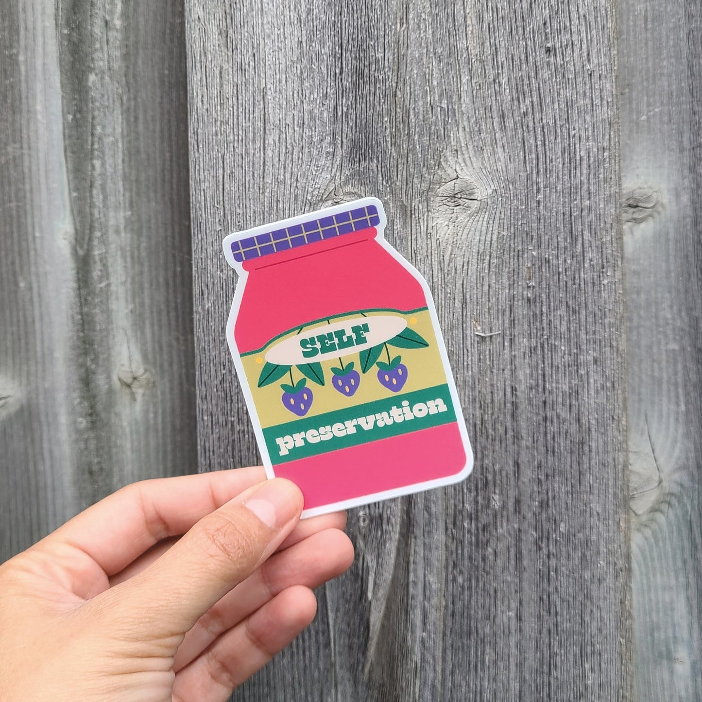 Colorful jam jar with purple berries that says "self preservation". Made in Canada by Mad Love Creative Co.