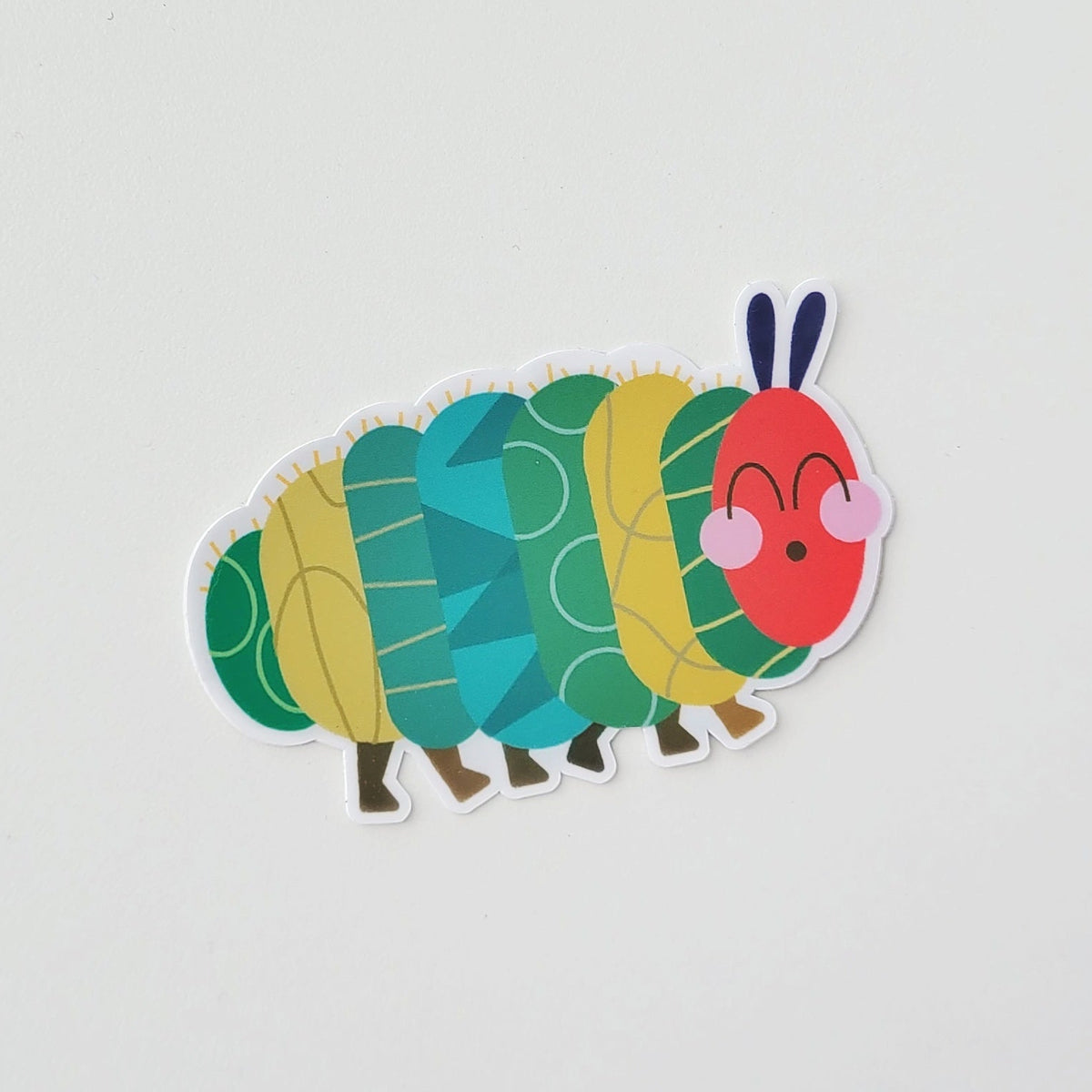 Colorful Hungry caterpillar sticker on a light gray background