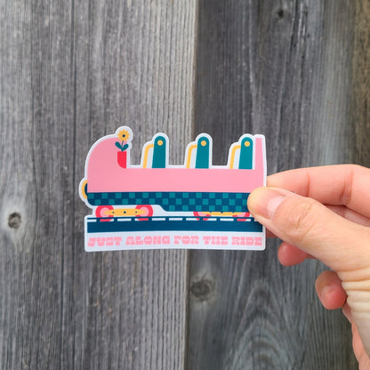 Cute sticker featuring a rollercoaster cart with the text "just along for the ride". Made in Canada by Mad Love Creative Co. 