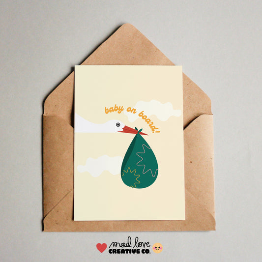 Cute card featuring a stork carrying a parcel with the phrase "baby on board". Made in Canada by Mad Love Creative Co. 