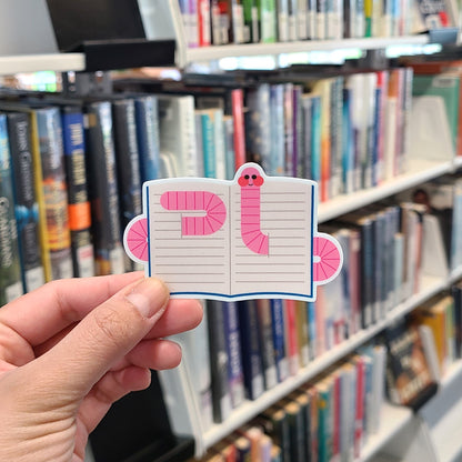 Cute vinyl bookworm sticker featuring a worm in a book. Made in Canada by Mad Love Creative Co. 