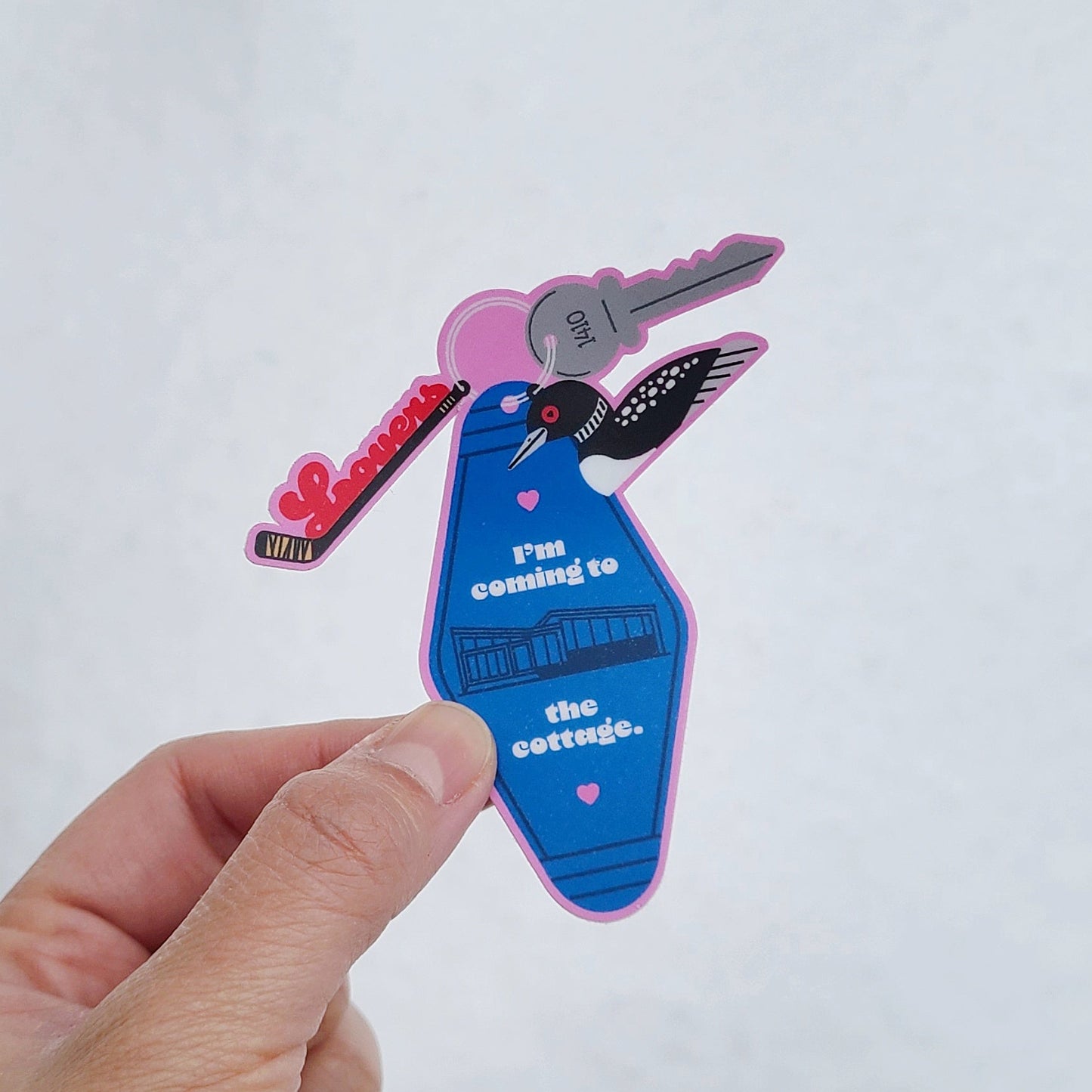 Cute sticker of a motel keychain with icons inspired by a Canadian hockey-themed LGBTQ TV show. Made in Canada by Mad Love Creative Co. 