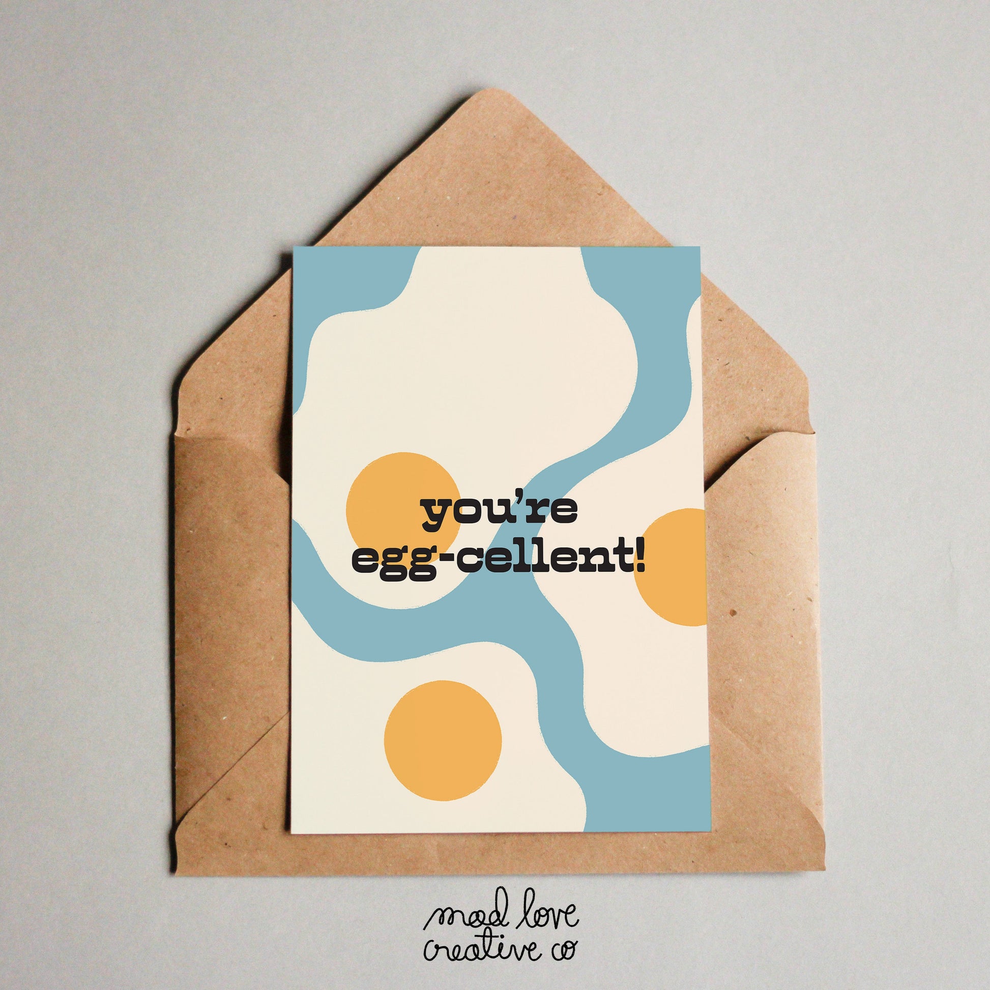 Cute card featuring sunny side up eggs on a light blue background with the text "you're egg-cellent". Made in Canada by Mad Love Creative Co. 