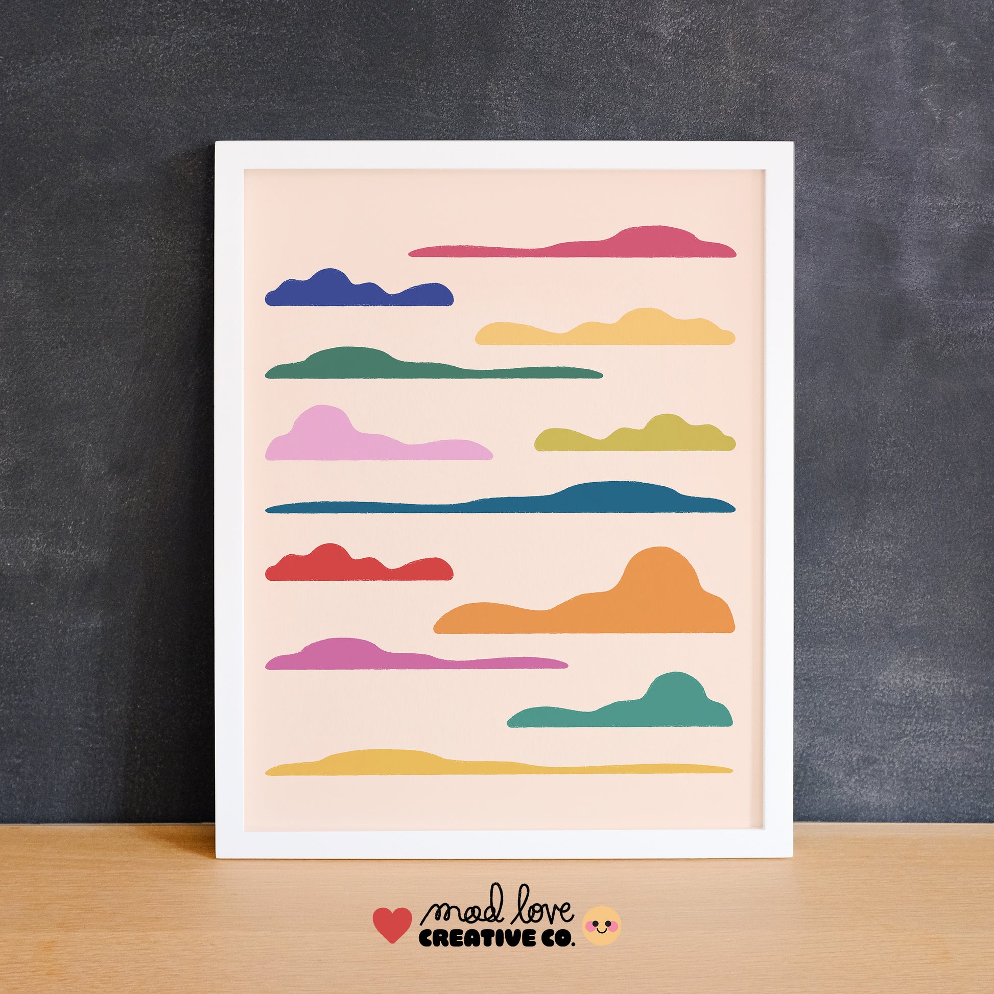 Framed artwork mockup with colorful cloud shapes on a purple wall. Made in Canada by Mad Love Creative Co. 