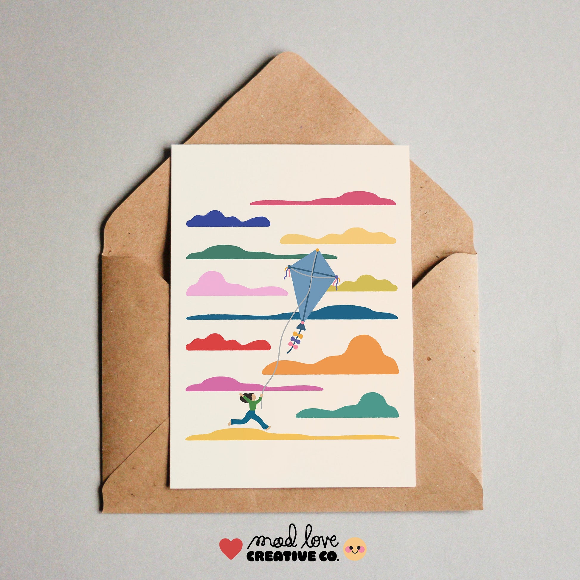 Card with colorful s cloud and kite design on a brown envelope. Made in Canada by Mad Love Creative Co. 