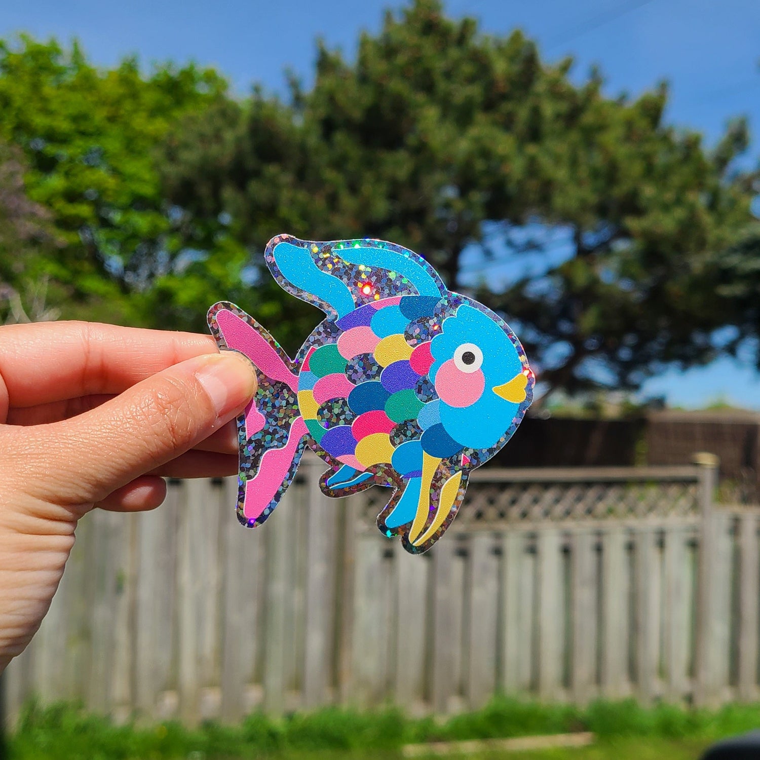 Cute glitter vinyl sticker of the book character Rainbow Fish. Made in Canada by Mad Love Creative Co.