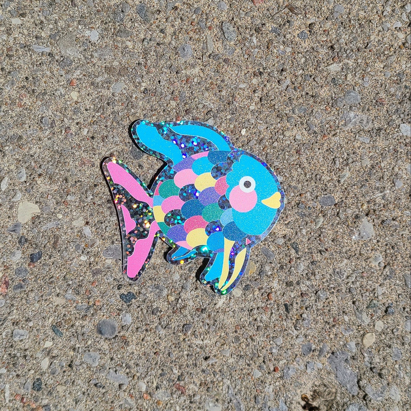 Bright blue glittery vinyl sticker of the children's book character, Rainbow Fish. Made in Canada by Mad Love Creative Co.