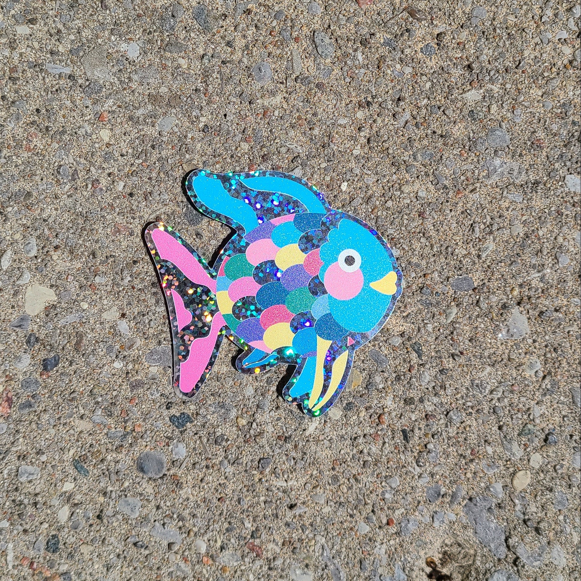 Bright blue glittery vinyl sticker of the children's book character, Rainbow Fish. Made in Canada by Mad Love Creative Co.