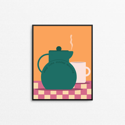 Framed artwork of a teal teapot and white mug on a checkered tablecloth with an orange background with the text "easy like Sunday morning". Made in Canada by Mad Love Creative Co. 